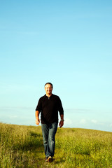 Mann läuft durch halbhohes Gras 750