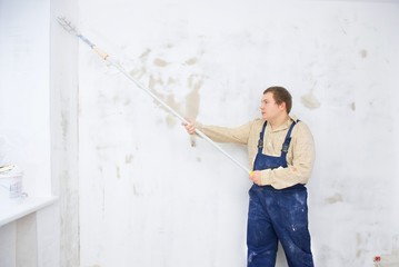 Man painting wall with roller