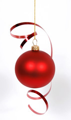 Hanging red glass ball with the ribbon on the white background