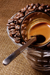 Espresso shot in a bowl of coffee beans.