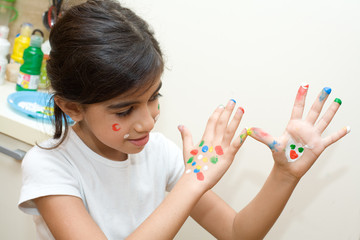 bambina che gioca con le mani pitturate