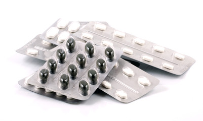 Pills of many shapes and colors grouped together