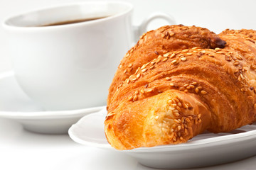 Breakfast: coffee and croissant with sesame seeds