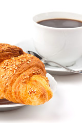 Breakfast: coffee and croissant with sesame seeds