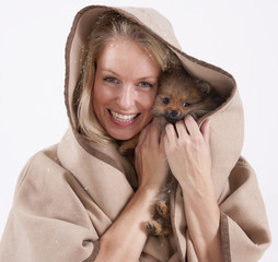Young woman with a pomeranian puppy in the hood