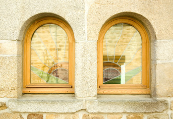 Two windows with stained glass in stone wall close-up