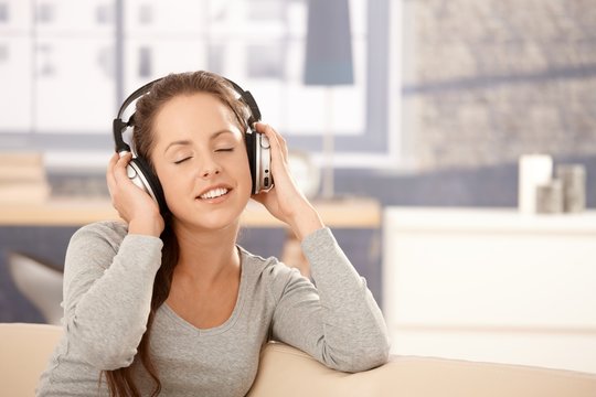 Young woman enjoying music through headphones