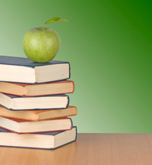 Books and apple on leaf