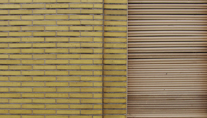 yellow brick wall with white roller shutter