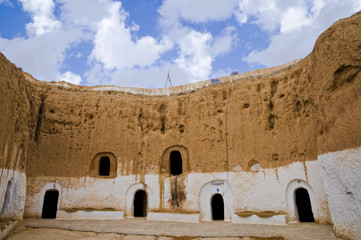 Berber caves with blue sky and white clouds in Tunisia