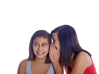girl whispering to her smiling sister