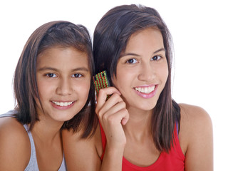 smiling teenage girls holding phone to ear