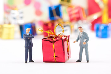Figurines of two businessmans with Christmas gift