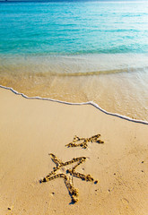 Drawing on sand on a theme of rest - a starfish and a small fish