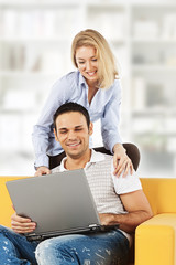 Happy couple with laptop computer