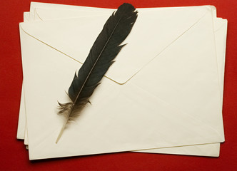 Envelope with feather isolated on red background