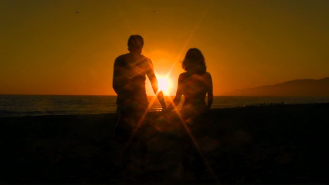 Newlyweds walk into sunset holding hands - HD