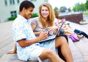 Closeup of happy young friends using laptop