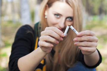 Blond girl breaking a cigarette