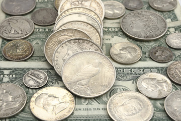 ancient american silver coins on the one dollar bill background