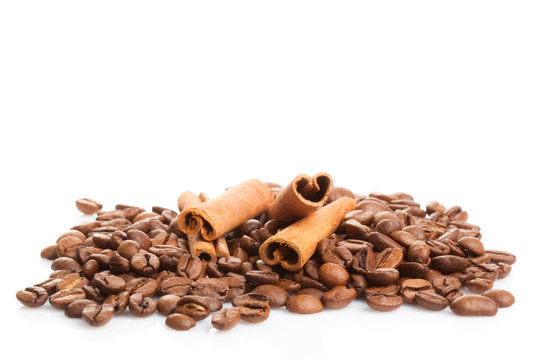 Cinnamon sticks and coffee beans on white background