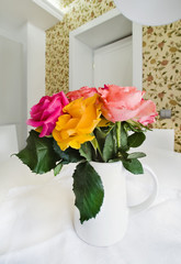 Colored roses in white vase