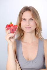 Beautiful blond woman eating strawberries