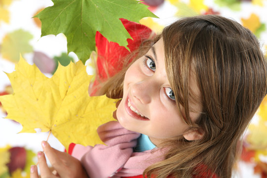 enfant photographié avec des feuilles d'automne