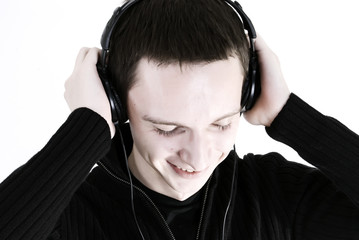 Young man in headphones relaxing under the sounds of music