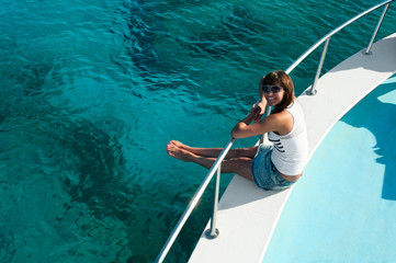 Woman sitting on edge of yacht