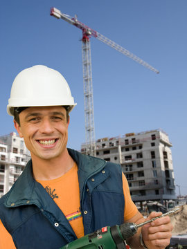Homme tenant une perçeuse sur un chantier