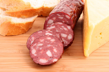 Sausage and bread on wooden surface