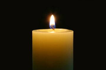 A single burning candle isolated with black background