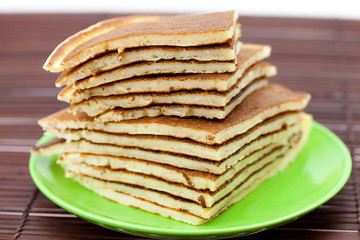 Pancakes on a plate on a bamboo mat