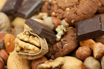 oatmeal cookies, chocolate and nuts on a wicker mat