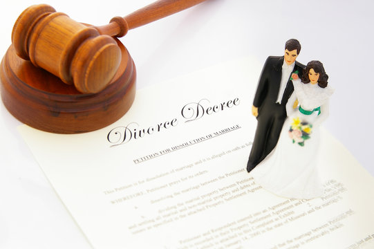 cake-topper wedding couple, divorce agreement and a gavel