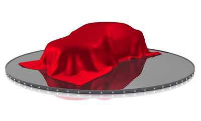 Auto unter rotem Tuch auf Podest
