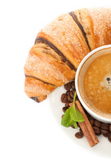 Cup of coffee with coffee beans, cinnamon sticks and chocolate c