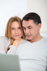 Happy couple surfing on internet at home