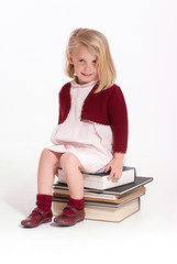 Little girl sitting on books