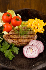 Bistecca di Manzo con verdure su tavola di legno