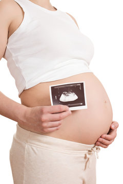 pregnant woman is holding a photo of her Ultrasound