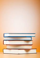Stack of text books against gradient background