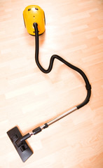 Vacuum cleaner on the polished wooden floor