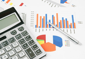 Pen and calculator on paper table with diagram