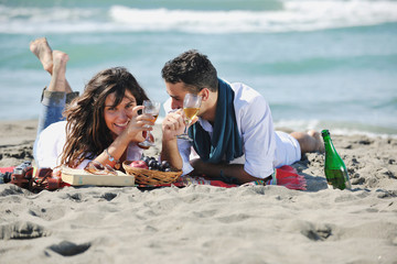 young couple enjoying picnic on the beach