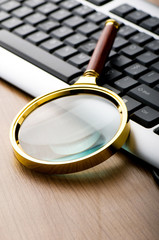 Computer security concept with keyboard and magnifying glass