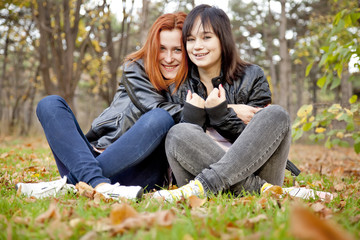 Two girlfriends at the autumn park.