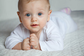 Adorable newborn boy lying on bed