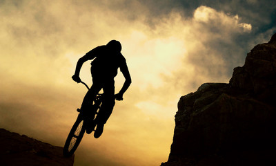 Silhouette of a man on muontain-bike, sunset